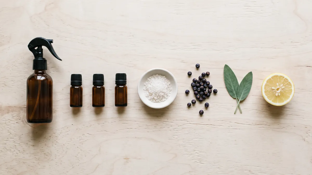 Zutaten für ein selbstgemachtes Raumspray mit ätherischen Ölen, Wacholderbeeren und Salbei